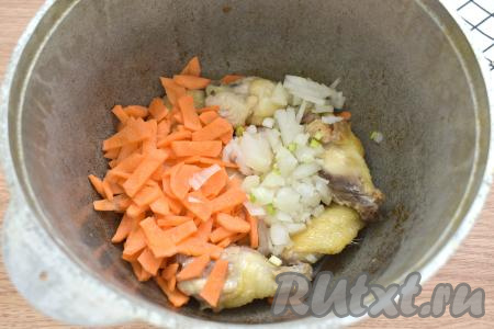 Лук нарезаем достаточно мелко, морковь - на достаточно тонкие брусочки, выкладываем к обжаренным крылышкам, перемешиваем, обжариваем 5 минут, иногда перемешивая.