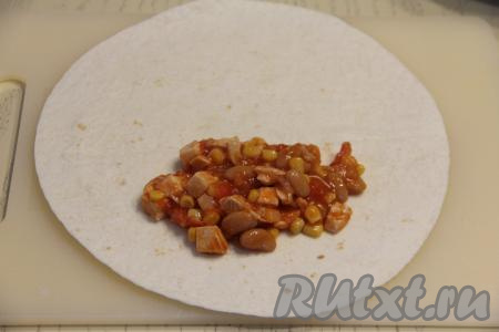 Выложить примерно 3 столовых ложки начинки на одну половину лепёшки "Тортилья", немного отступив от краёв.