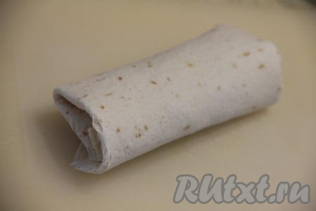 Подогнуть края лепёшки с двух сторон. Затем, начиная со стороны с начинкой, свернуть тортилью в рулет. Таким образом сформировать все бурито с курицей и фасолью. У меня получилось 6 штук.