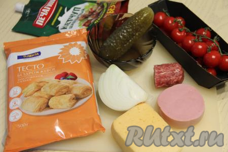 Подготовить продукты для приготовления пиццы из слоёного теста с солёными огурцами. Помидоры вымыть, лук почистить. Слоёное тесто разморозить при комнатной температуре.