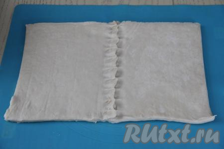 Слоёное тесто у меня было в двух пластах. Я выложила на присыпанную мукой поверхность рядом 2 пласта и скрепила их между собой с помощью шва.