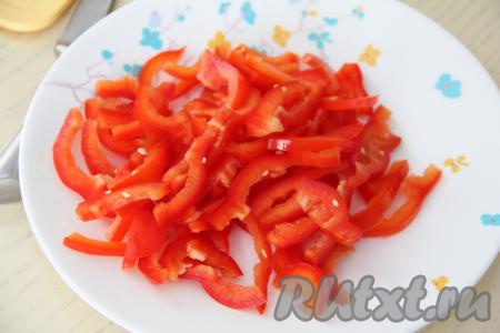 Очистить болгарский перец от семян, промыть его водой и нарезать на длинные полоски.