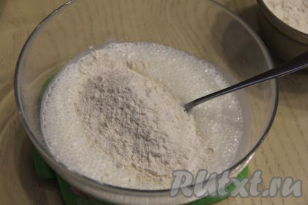 По прошествии 4-5 минут смесь кефира и соды увеличится в объёме и покроется пузырьками. В смесь кефира и соды добавить соль, всыпать 300 грамм муки.