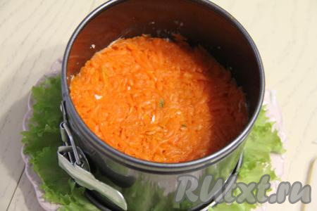Следующим слоем будет очищенная и натёртая на крупной тёрке морковка, слегка утрамбовать слой.