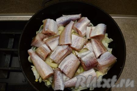 В сковороду, прямо на лук, выложить кусочки минтая. Накрыть сковороду крышкой, уменьшить немного огонь и тушить рыбу в течение 10 минут.