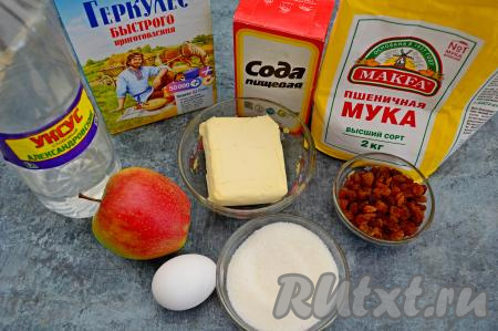 Подготовить продукты для приготовления овсяного печенья с яблоками и изюмом. Сливочное масло заранее достать из холодильника, чтобы оно нагрелось до комнатной температуры (если же времени мало, то совсем немного подогрейте масло в микроволновке, масло должно статья мягким, но не растопленным). Сразу же залить кипятком изюм и оставить на 5-10 минут пропариться. Затем изюм откинуть на сито, промыть и выложить обсыхать на бумажные салфетки.