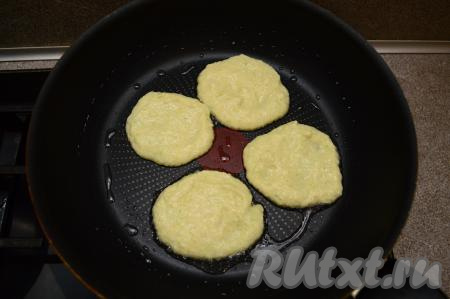 Сковороду разогреть с добавлением растительного масла, уменьшить огонь до среднего. Затем выкладывать в сковороду по 1 столовой ложке кабачкового теста, формирую небольшие округлые оладьи. Жарить оладьи из замороженных кабачков 2-3 минуты (до румяной корочки снизу).