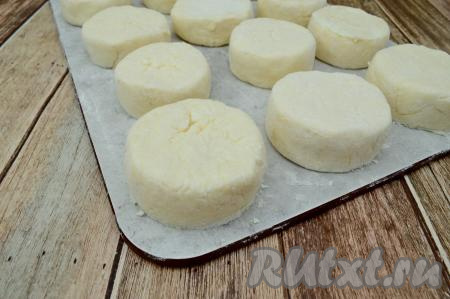 Аналогично сформировать оставшиеся сырники. Выложить их на припорошенную мукой доску. Всего у меня получилось 12 заготовок сырников. Если не собираетесь жарить все сырники сразу, то можно их заморозить прямо на доске, поместив в морозилку. Затем, когда заготовки заморозятся, сложить их в целлофановый пакет и убрать на хранение в морозилку. Жарить замороженные сырники можно, не размораживая, только на небольшом огне и более продолжительное время.