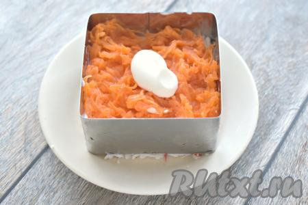 Третьим слоем салата равномерно раскладываем по формам морковку, натёртую на крупной тёрке, смазываем этот слой майонезом.