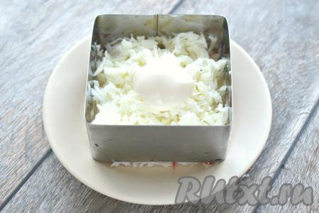 Куриные яйца разделяем на белки и желтки. Для второго слоя нам потребуются белки. Натираем их на крупной тёрке. Равномерно раскладываем натёртые белки по двум формам, слегка присаливаем их и смазываем майонезом.