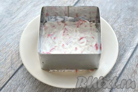 Смазываем слой из крабовых палочек майонезом.
