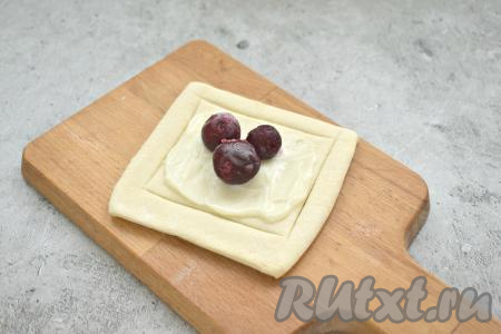 На творожный слой кладём 3-4 ягодки вишни.