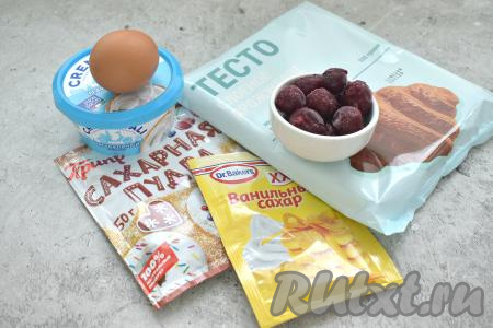 Подготовим ингредиенты для приготовления слоек с творожным сыром и вишней. Слоёное тесто предварительно нужно разморозить до мягкости при комнатной температуре. Для этой выпечки можно взять свежую или замороженную вишню. Если на замороженных ягодах нет большого количества льда, значит их можно не размораживать. Ягоды, на которых много льда, нужно разморозить и лишнюю воду слить. Свежую вишню нужно промыть водой, удалить косточки, немного обсушить ягоды.