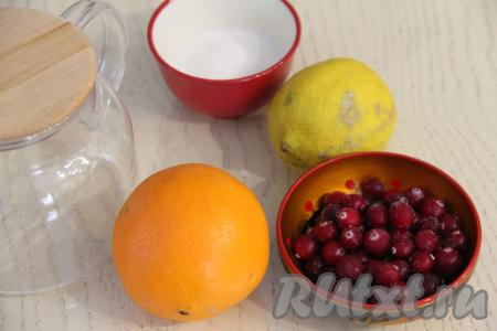 Подготовить продукты для приготовления чая с клюквой и апельсином в заварнике. Апельсин и лимон хорошо вымыть. Заварочный чайник обдать кипятком. Клюкве дать немного разморозиться.