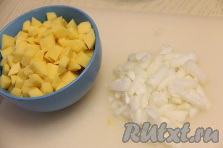 В кастрюлю налить 2 литра воды, поставить на огонь. Картошку нарезать на средние кубики. Лук мелко нарезать.