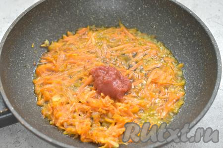 К обжаренным овощам добавляем томатную пасту, вливаем 3-4 столовых ложки воды из кастрюли, в которой варятся картошка и гречневая крупа, перемешиваем и тушим 3-4 минуты.