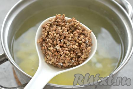 Перебираем заранее гречку, выкладываем в сито, хорошо промываем её под проточной водой, оставляем на несколько минут, чтобы с крупы стекла вода. После того как картошка проварится с момента закипания 5 минут, добавляем в кастрюлю подготовленную гречку, даём закипеть и варим 15 минут на небольшом огне.