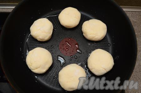 Сковороду разогреть с растительным маслом. Выложить на хорошо разогретую сковороду заготовки сырников и жарить их на среднем огне минуты 3 (до образования румяной корочки снизу).