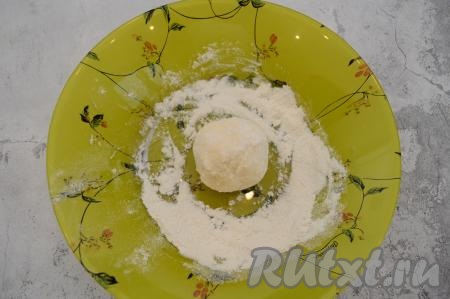 Я из указанного количества ингредиентов обычно готовлю 6 сырников. Поэтому перед формированием сырников зрительно делю тесто на 6 равных частей. Из каждой части теста влажными руками сформировать округлый сырник. На плоскую тарелку насыпать примерно 1 столовую ложку муки. Обвалять каждый сформированный сырник в муке со всех сторон. Благодаря тому, что мы лепим каждый сырник влажными руками, тесто не пристаёт к ладоням, а поверхность сырника становится более влажной и хорошо обваливается в муке.