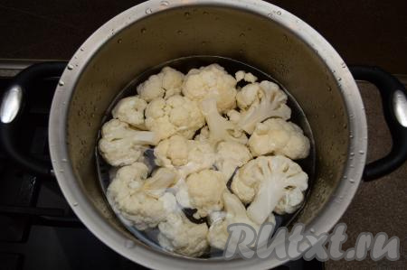 Выложить соцветия цветной капусты в кастрюлю, залить полностью водой, поставить на огонь. Отварить с момента закипания в подсоленной воде в течение 7-8 минут. Цветная капуста должна стать в меру мягкой, но при этом хорошо держать форму. Готовность можно проверить ножом, если нож легко входит в капусту, значит она готова. Сразу же слить воду и оставить капусту остывать.
