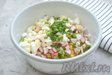 Зелёный лук моем, стряхиваем с него лишнюю воду, затем нарезаем и добавляем в салат.