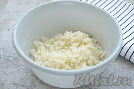 Крабовые палочки, если они заморожены, нужно будет достать заранее, чтобы они разморозились при комнатной температуре. Рис тоже можно сварить заранее. Для этого промываем рис, кладём его в кастрюлю с кипящей подсоленной водой, перемешиваем. После закипания варим рис до готовности (я варила 20 минут) на небольшом огне. Затем откидываем варёный рис на дуршлаг, промываем холодной водой, даём стечь воде. Теперь можно приступать непосредственно к приготовлению салата. Выкладываем рис в салатник.