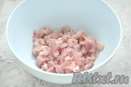 Заранее достаём из морозилки слоёное тесто (у меня тесто было в двух пластах) и оставляем его размораживаться при комнатной температуре. Моем мясо курицы (я взяла 2 окорочка, удалила с них кожу, срезала мясо с костей), обсушиваем. Нарезаем куриное мясо на очень маленькие кубики, перекладываем их в миску.