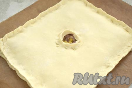 Второй пласт теста на присыпанном мукой столе тоже раскатываем до толщины 3 миллиметра. Этим пластом теста накрываем тесто с начинкой. Скрепляем края курника со всех сторон, в центре делаем отверстие для выхода пара.