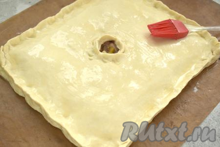 В небольшой ёмкости взбиваем яйцо вилкой и смазываем им поверхность курника.