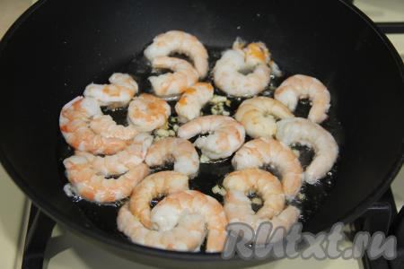 Затем выложить креветки в сковороду.