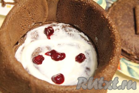 Выложить немного вишнёвой начинки. Накрыть начинку следующим блином, смазать частью крема, выложить часть начинки из вишни.