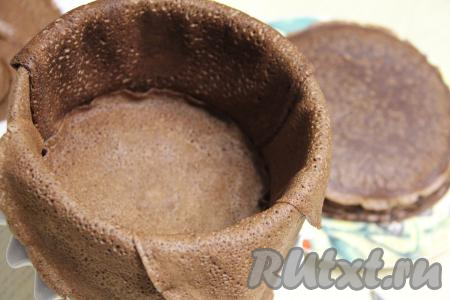 Блинный торт я формировала с помощью кулинарного кольца диаметром 20 сантиметров, поставив его на плоскую тарелку. Бортики кулинарного кольца выстелить внахлёст блинами диаметром 23 сантиметра. Края блинов должны свисать с бортиков формы.&nbsp;На дно формы выложить блин диаметром 20 сантиметров. Для того чтобы этот блин и последующие блины диаметром 20 сантиметров полностью помещались внутрь формы (но при этом края блинчиков должны доходить до бортиков формы), я совсем немного обрезала края этих блинов, приложив сверху тарелку соответствующего размера.&nbsp; 