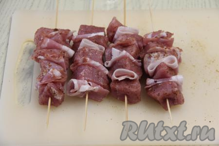 Нанизать, чередуя, мясо с беконом на 4 деревянных шпажки. У нас получатся 4 шашлычка на шпажках.