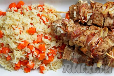Вкусные, сочные шашлыки на шпажках вместе с рассыпчатым, аппетитным рисом достать из банки, переложить на тарелку и подать к столу в горячем виде.​​​​​​​ 