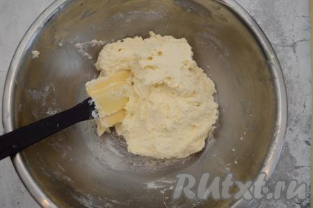 Вмешать муку в тесто, а затем начать добавлять муку постепенно, по столовой ложке. Замешиваем тесто сначала вилкой, а когда оно начнёт густеть, продолжаем выполнять замес лопаткой. Консистенция теста для сырников должна получиться комковатой, липкой, но при этом хорошо держащей форму. Мне всего потребовалось добавить 100 грамм муки.