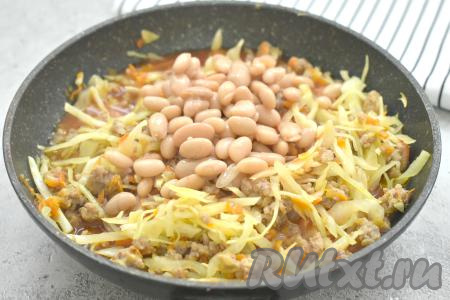 Консервированную фасоль заранее откидываем на дуршлаг, ополаскиваем холодной водой, лишней воде даём стечь. Фасоль добавляем в сковороду сразу за томатным соусом, перемешиваем. Сковороду накрываем крышкой, даём соусу закипеть и, убавив огонь, тушим капусту с фаршем и фасолью 20-25 минут (до мягкости капусты), периодически перемешиваем.