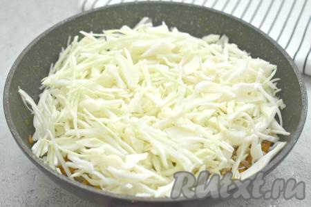 Затем выкладываем в сковороду капусту, нарезанную на тонкие полоски, перемешиваем и обжариваем 7-8 минут.