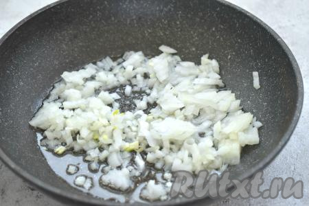 Пока варятся капуста с картошкой, займёмся обжариванием овощей. Для этого прежде всего очищаем морковку и лук. Прогреваем на сковороде растительное масло, выкладываем мелко нарезанную луковицу и обжариваем в течение 3-4 минут (до прозрачности лука) на среднем огне, иногда помешивая.