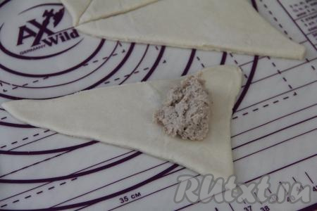 Начинку из мяса курицы и лука зрительно разделить на 8 частей (по количеству заготовок теста). Взять один треугольник из теста, ближе к основанию треугольника выложить одну часть начинки, немного отступив от краёв.&nbsp;