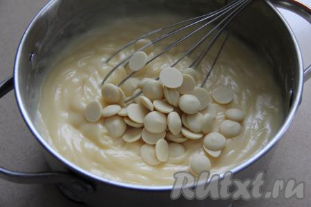 Снять кастрюлю с огня, в получившийся заварной крем сразу добавить белый шоколад, поломанный на кусочки (или шоколадные капли).