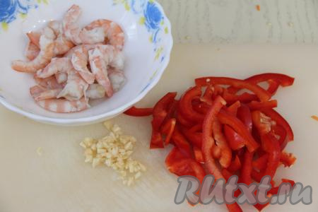 Креветки очистить от головы и панциря. Если креветки крупные, тогда нужно вынуть тонкую кишку, которая проходит поверх хвостовой части каждой креветки. Болгарский перец нарезать на длинные брусочки, чеснок - мелко.