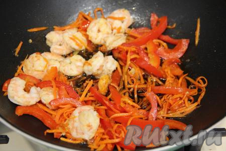 Обжарить креветки по 1 минуте с каждой стороны. Затем перемешать креветки с овощами. Влить соевый соус и добавить немного соли, перемешать, потомить 1 минуту.