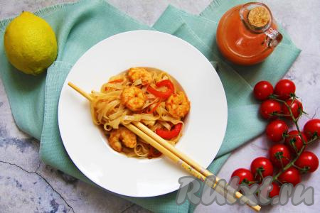 ​​​​​​​​​​​​​​​​​​​​​​​​​​​​Рисовую лапшу, приготовленную с креветками и овощами в соевом соусе, разложить со сковороды по тарелкам и в горячем виде подать яркое, вкусное и сытное блюдо к столу.