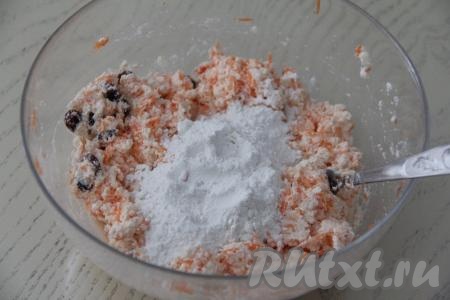 Перемешать творожно-морковную массу с изюмом, всыпать ванилин и половину муки. Ещё раз перемешать до однородности.