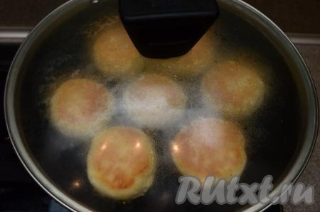 Ещё раз перевернуть сырники, накрыть их крышкой, выключить огонь и дать им пропариться в течение 3-5 минут.