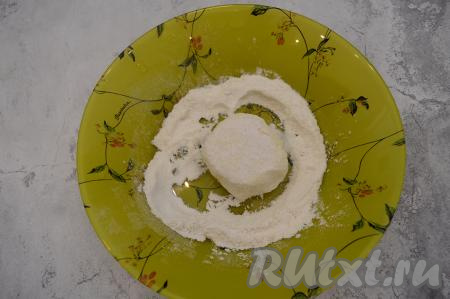 На небольшую тарелку насыпать муку. Обвалять сформированный сырник в муке со всех сторон.
