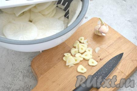 Зубчики чеснока нарезаем на тонкие пластинки.