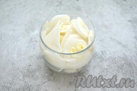 Нарезанные дайкон и чеснок, чередуя, выкладываем в небольшую банку. Не нужно заполнять банку слишком плотно.