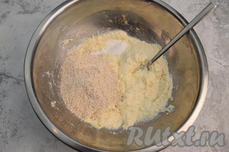 Всыпать овсяные хлопья и разрыхлитель в миску с творожно-банановой массой, тщательно перемешать вилкой.