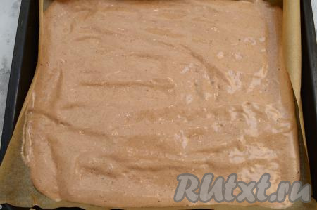 Противень (я использовала противень размером 30х40 сантиметров) застелить пергаментом (или силиконовым ковриком). На застеленный противень вылить тесто, разровнять его силиконовой лопаткой. Очень важно для этой выпечки выбрать качественный пергамент, к которому корж не будет приставать в процессе выпечки. Я предпочитаю использовать силиконизированную бумагу (о наличии силикона в составе бумаги указано на упаковке бумаги), её можно купить практически в любом магазине в отделе, где продаётся пергаментная бумага.